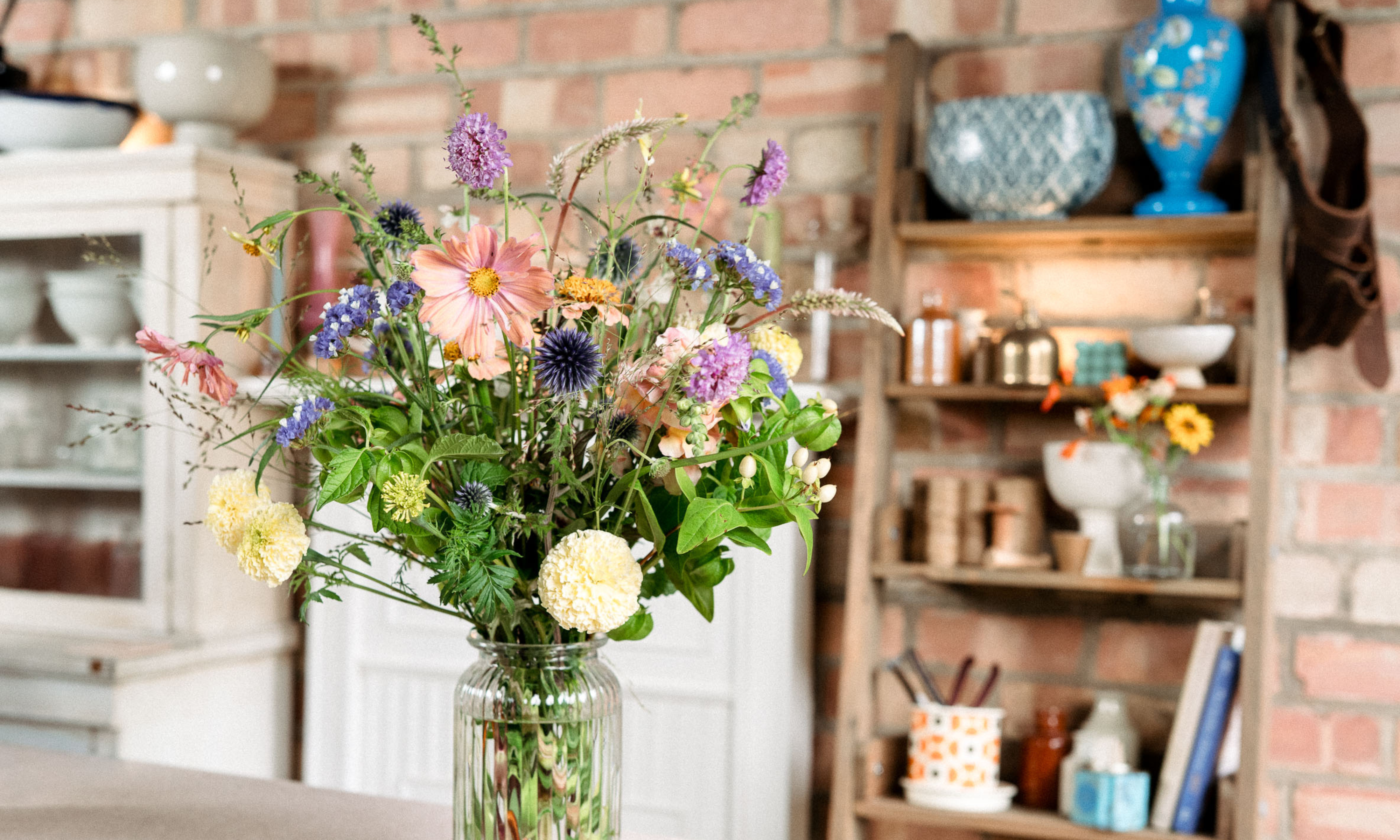 Bouquet of late summer garden flowers in glass vase