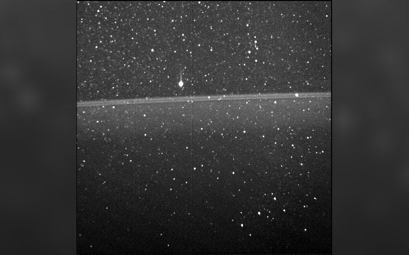 A monochrome image showing a thin band across the middle of the image &amp;mdash; Jupiter's ring structure.