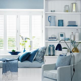 Living room with blue accents, window with window blinds, daybed