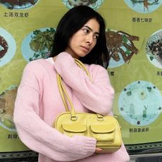 Michelle Li wearing a pink sweater and yellow cargo handbag in NYC