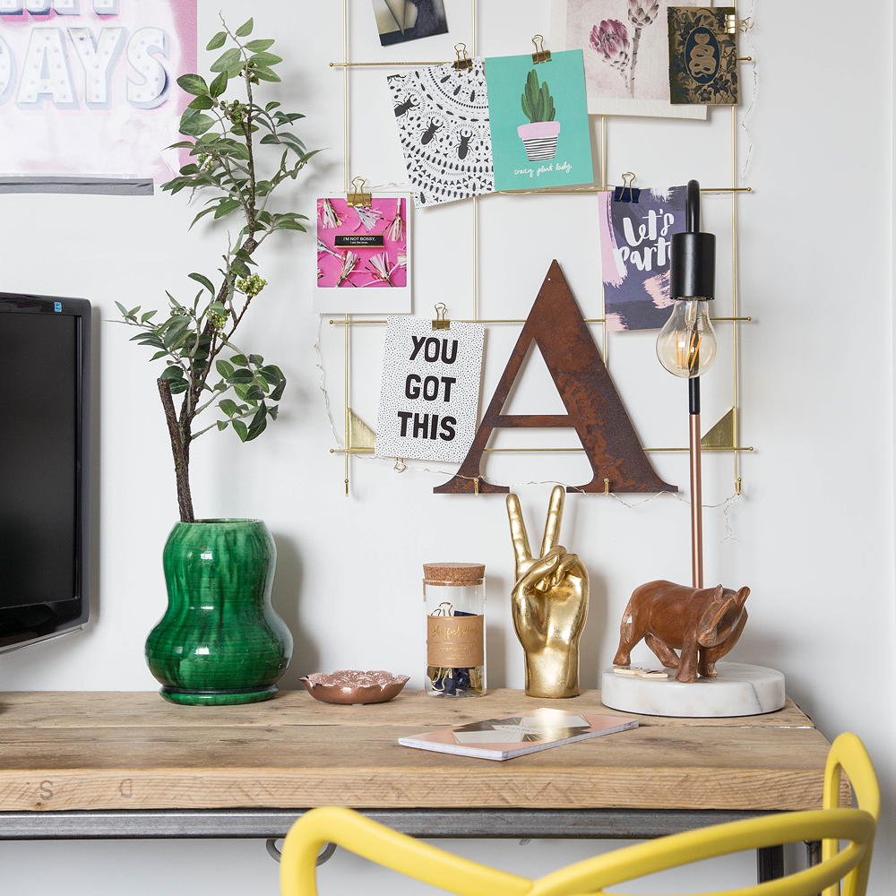 room with table having wooden top and potted plant