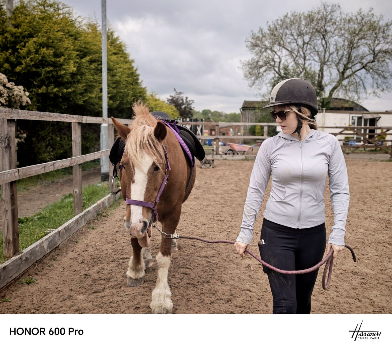 Rider leading a saddled pony around an outdoor arena