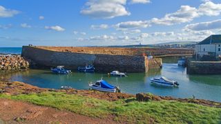 Harbour at Dunbar, East Lothian, with a path in the foreground and boats and the harbour wall in the background