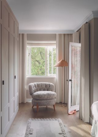 The built in wardrobes in the bedroom, looking towards a chair by the window