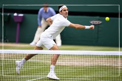 a medium shot of tennis star Roger Federer playing Wimbledon in 2021