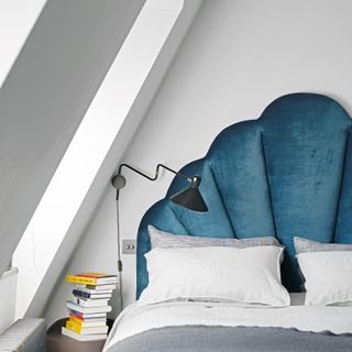 Blue scalloped headboard on bed