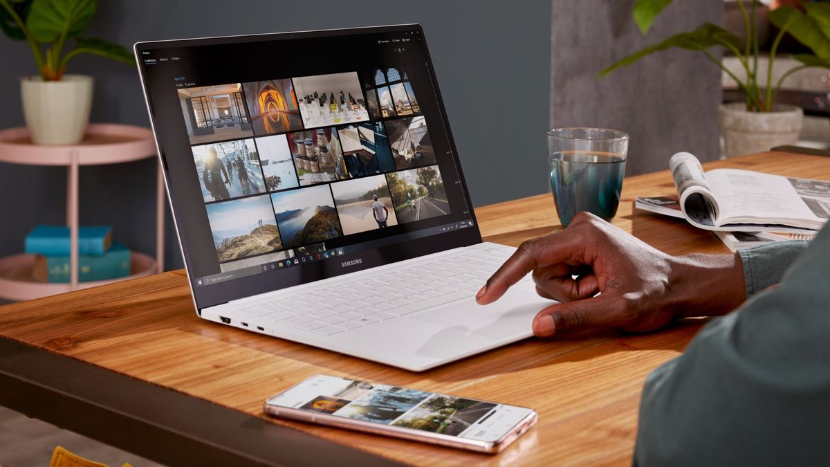 A laptop and smartphone sitting on a desk, being used to view images