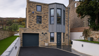 contemporary self build with asphalt driveway and retaining walls
