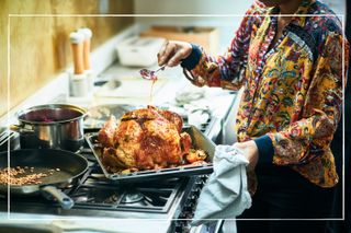woman basting a turkey for Christmas dinner