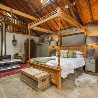 bedroom with wooden roof and bed with pillows