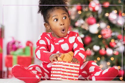 Child opening Christmas present to find a bear