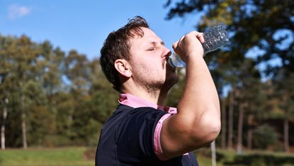 A golfer taking a drink of water