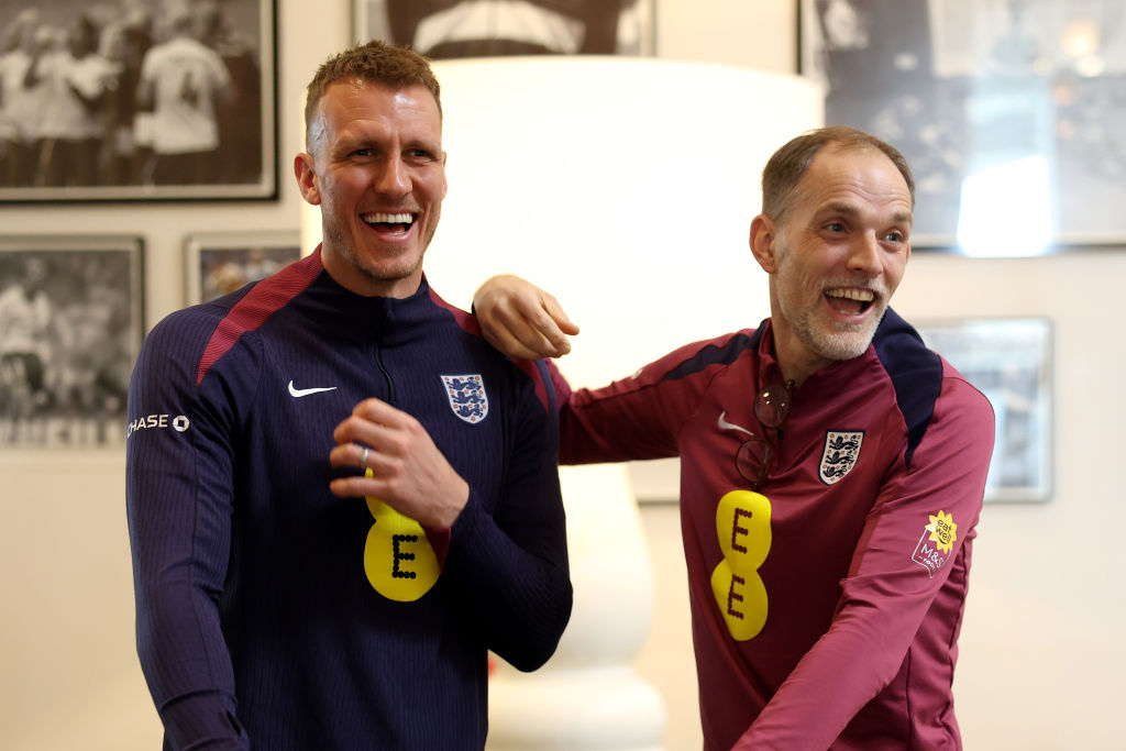 Thomas Tuchel, Head Coach of England, greets Dan Burn of England as he arrives at St George's Park on March 17, 2025 in Burton upon Trent, England