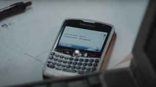 A close-up of a Blackberry phone on a white table during the movie Blackberry.