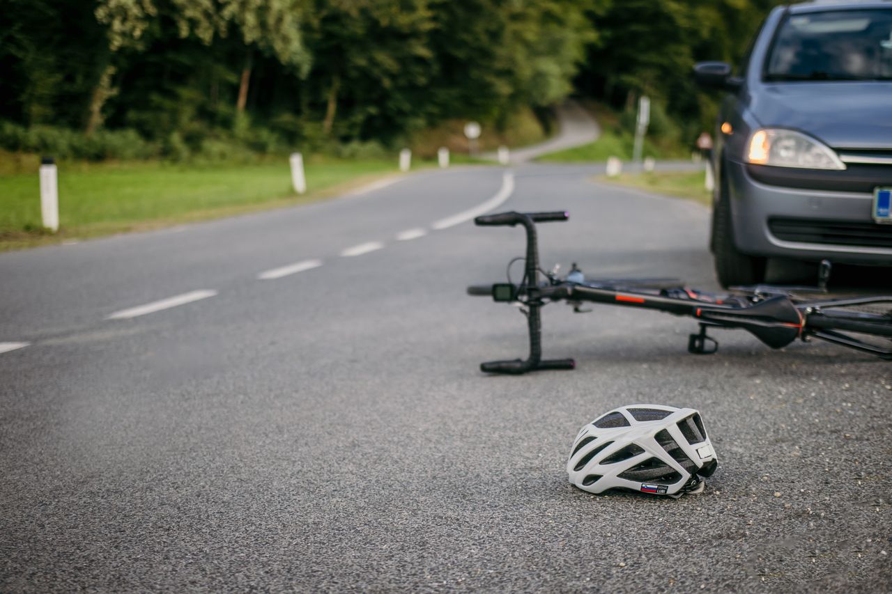 A helmet lies in the road after a bike crash