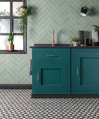 a black and white geo floor in a blue/green kitchen with a green herringbone tiled wall