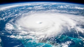 Here we see a huge hurricane in a satellite image against the blue ocean background.