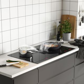 kitchen with tiles on wall and grey drawers