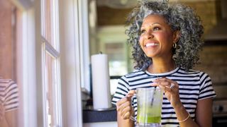Happy woman drinking green smoothie