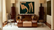 Art Deco living room with velvet sofa, lacquer wood table, iron chairs and abstract art