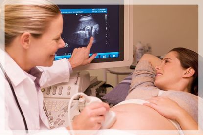 Pregnancy ultrasound: a woman examines her baby's ultrasound with the sonographer