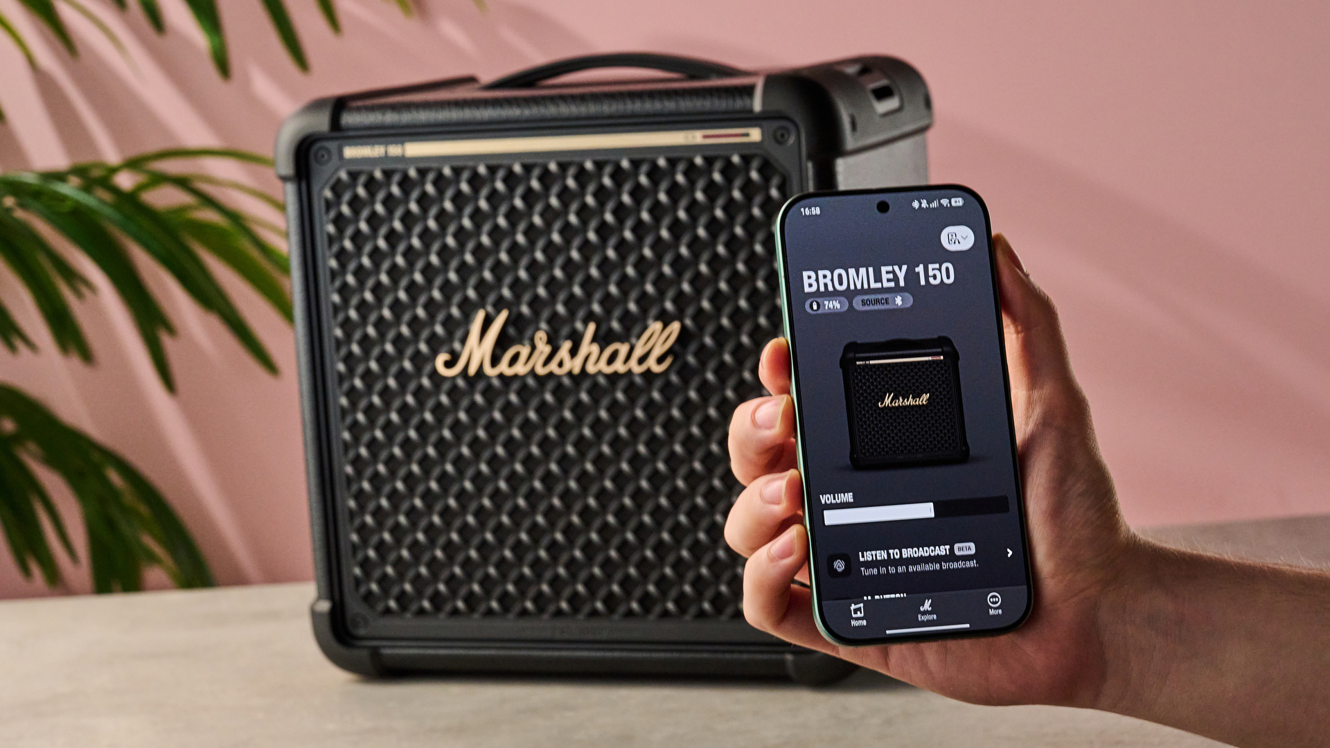 Man holding phone with Marshall Bluetooth app in front of the Marshall Bromley 150