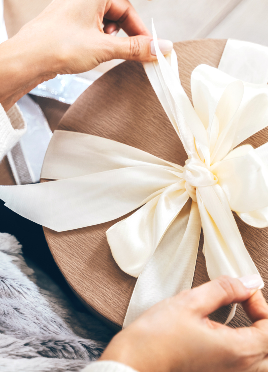 Woman wrapping a gift with ribbon
