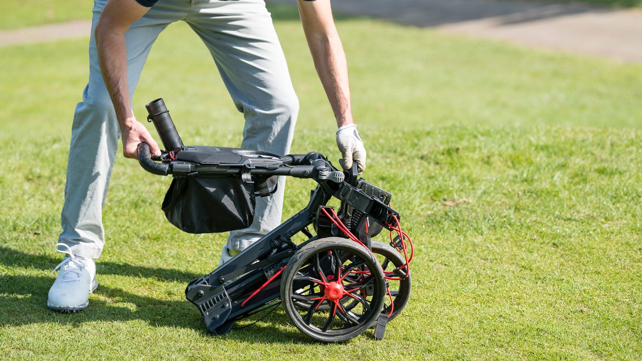 A golfer sets up the Bag Boy Nitron Push Cart