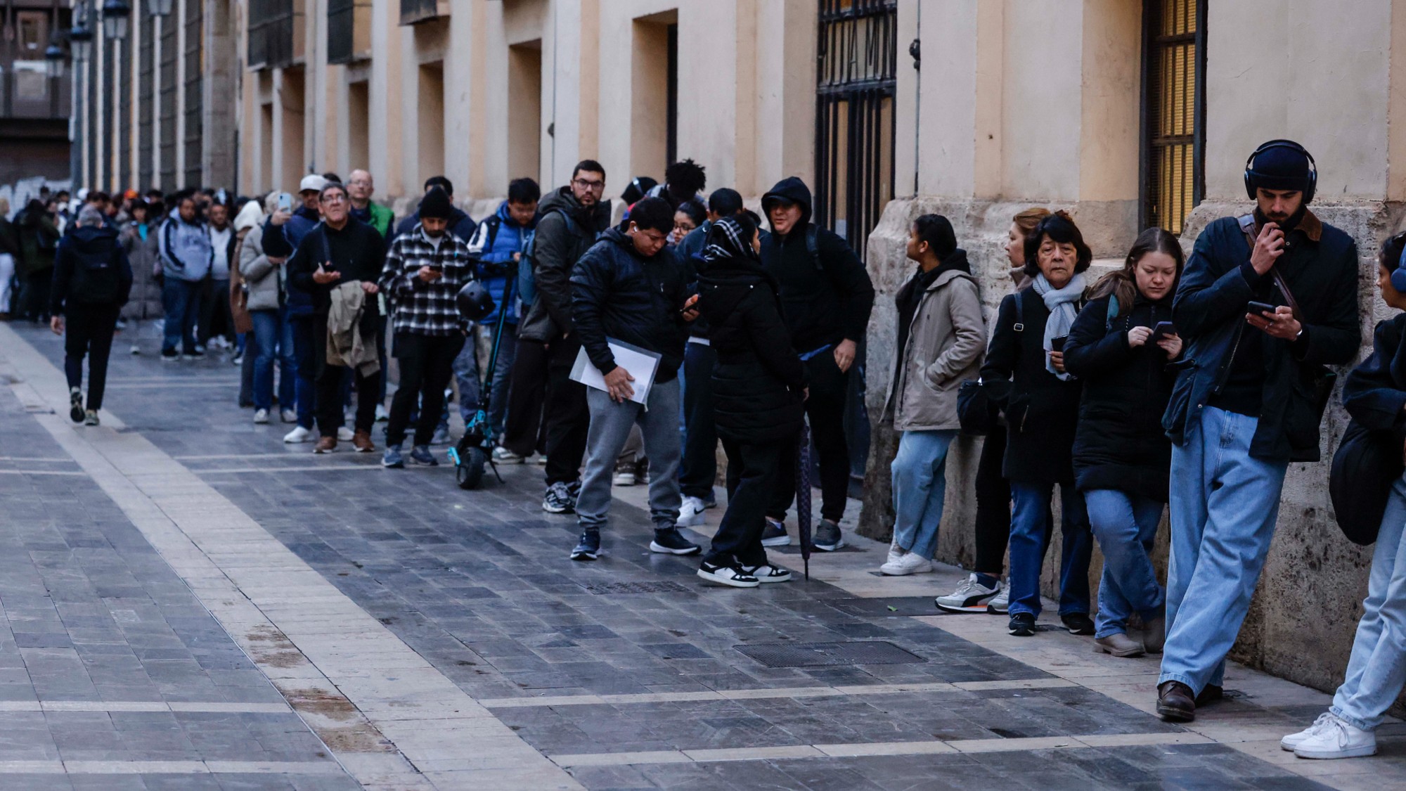 Migrants line up to receive paperwork at city hall in Valencia, Spain. 