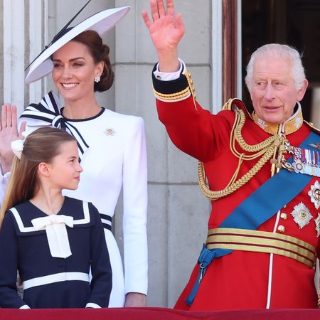 King Charles waving next to Princess Kate and Princess Charlotte