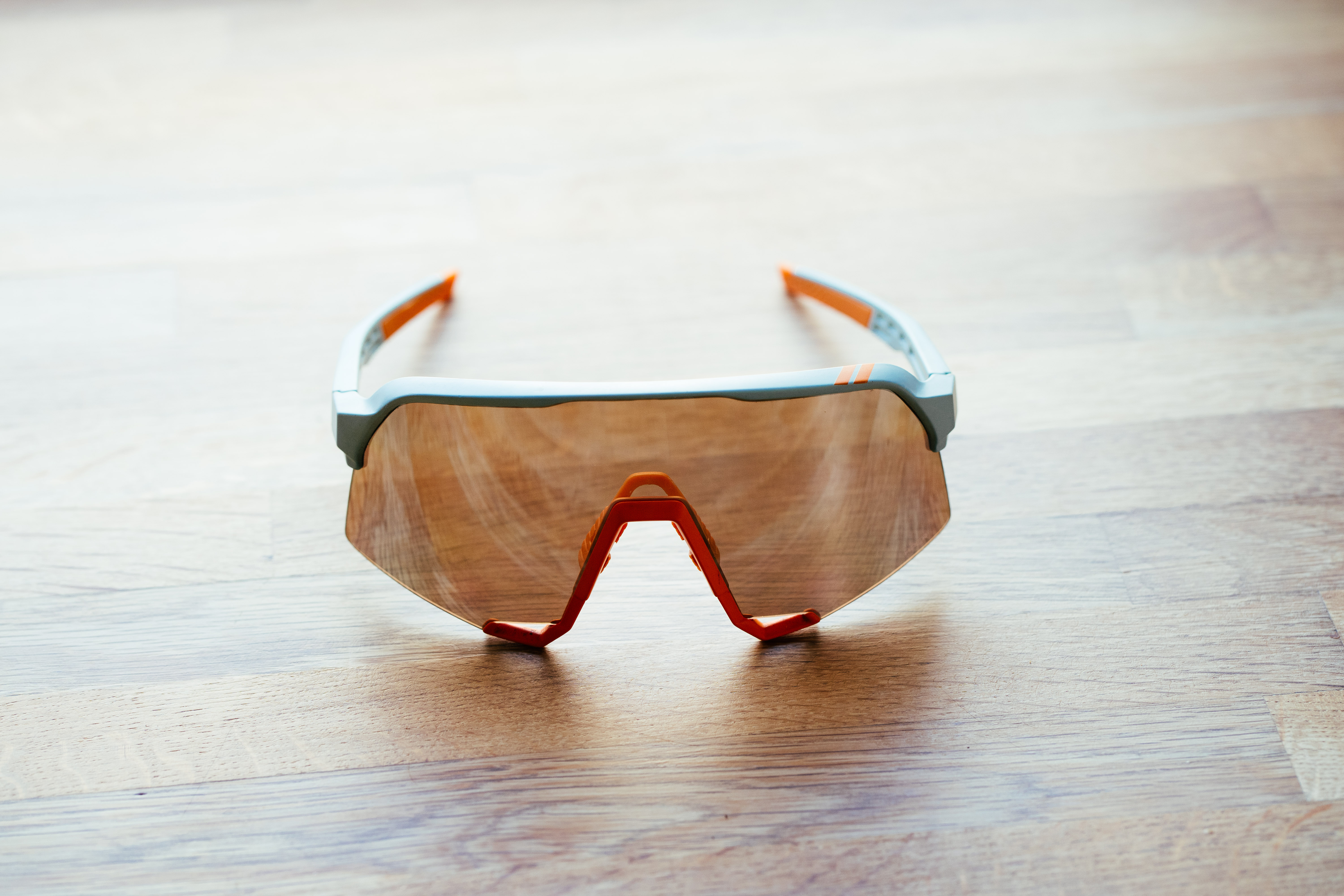 A blue framed set of sports glasses on a wooden surface
