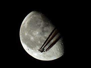 Plane Crosses in Front of Moon Seen from Romania