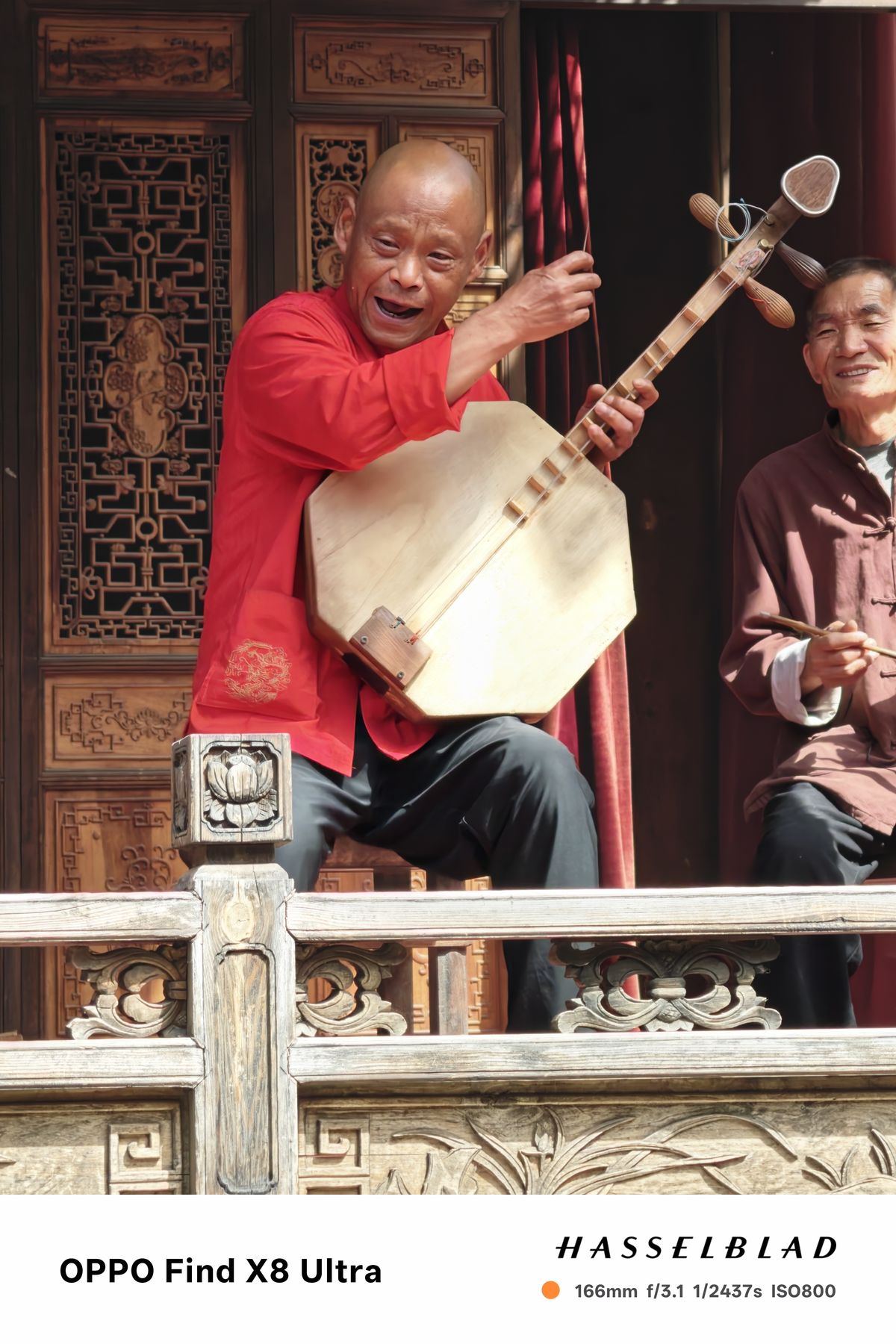 A person in traditional Chinese dress playing an instrument