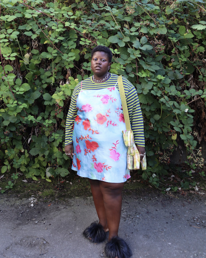 Lydia Okello wearing a layered floral dress over a striped shirt