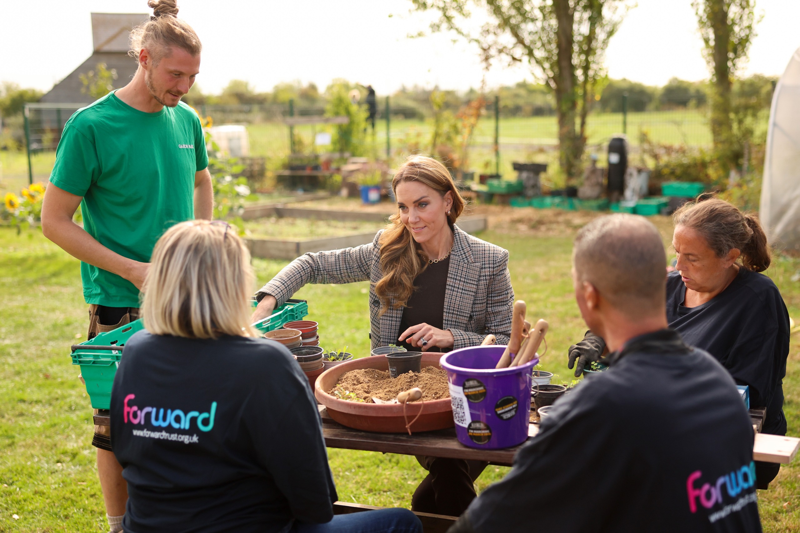 Princess Kate sitting at a picnic table with a group of people