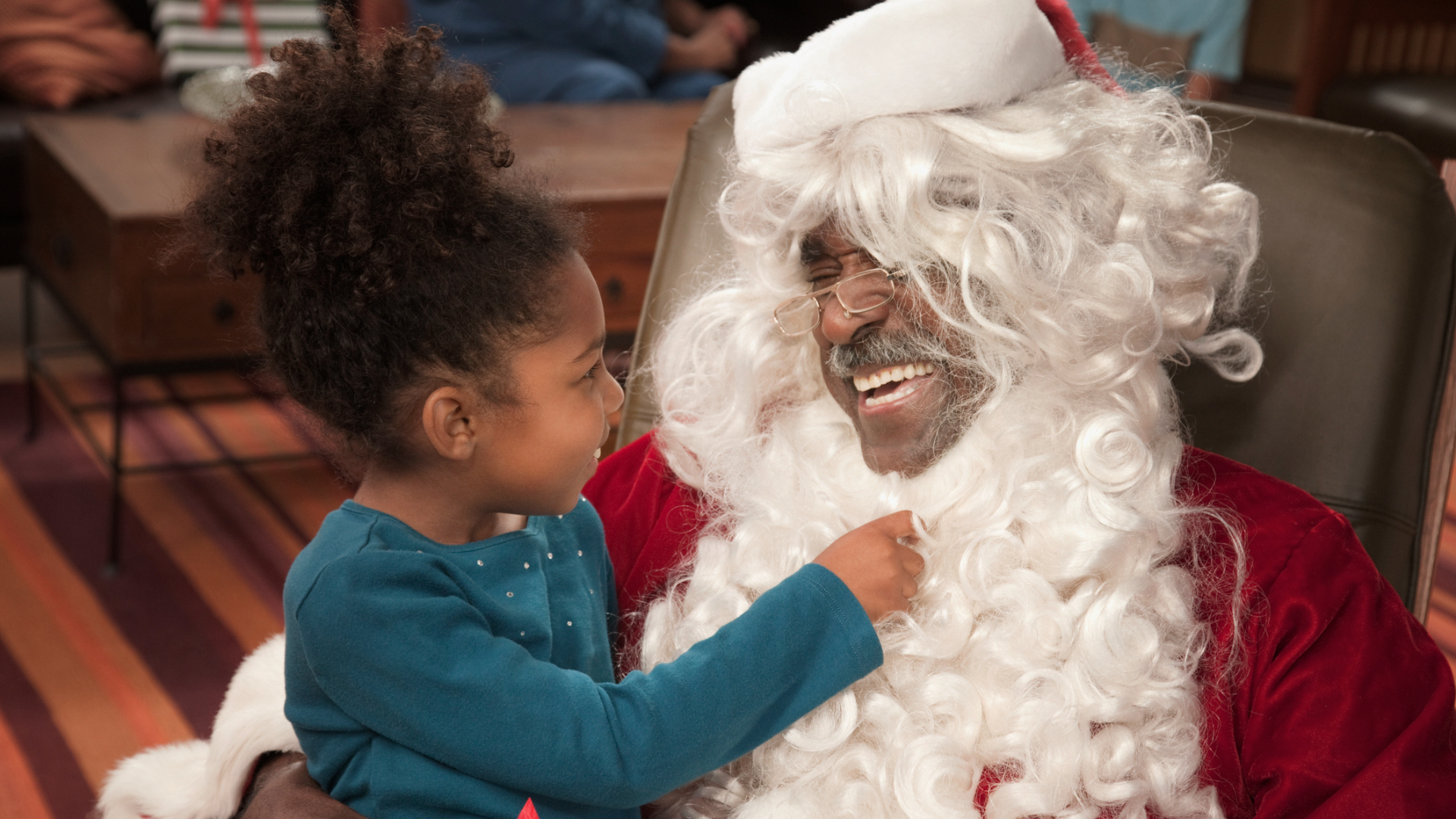 Child pulling at the beard of Santa