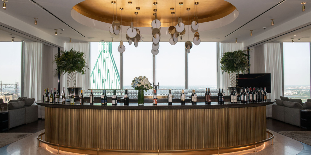 A bar with wine bottle backlit by windows. 