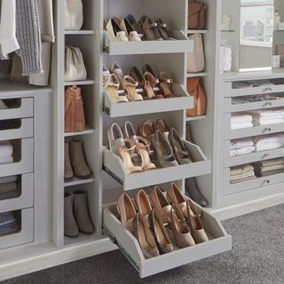Grey pull out shelves for shoes in a bedroom