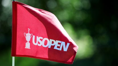 A red US Open flag blows in the wind