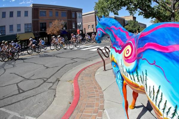 The race rolls out past painted horses along Main Street.