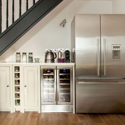 kitchen station with white wall and freezer with cabinets