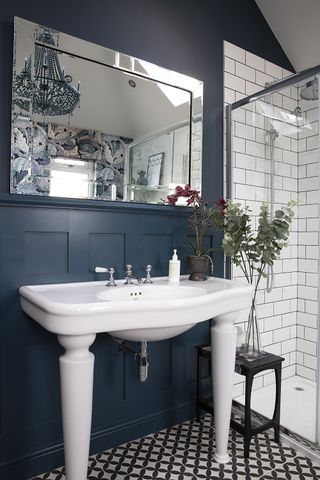 dark bathroom with large basin and panelled walls and patterned flooring