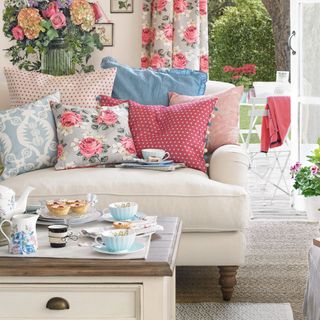 living room with sofa and cushions and floral curtains