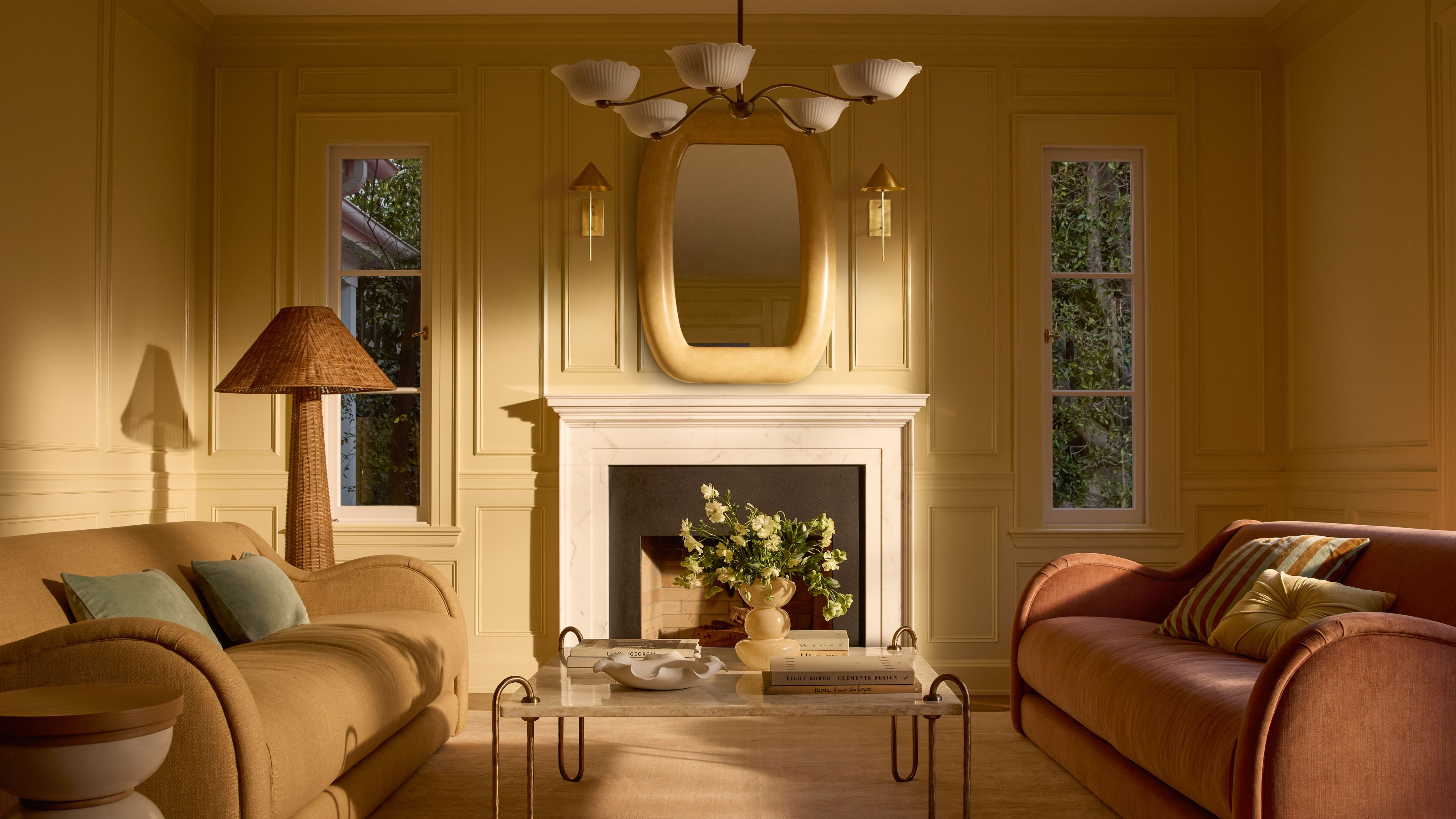 Cheerful yellow living room featuring ochre and terracotta velvet-upholstered sofas, a sculptural sofa, and woven floor lamp