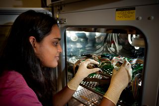 Vaishnavi Srinivasaraghavan, VT MEMS Lab's graduate student, placing a microchip inside an incubator for electrical impedance sensing of living cells.