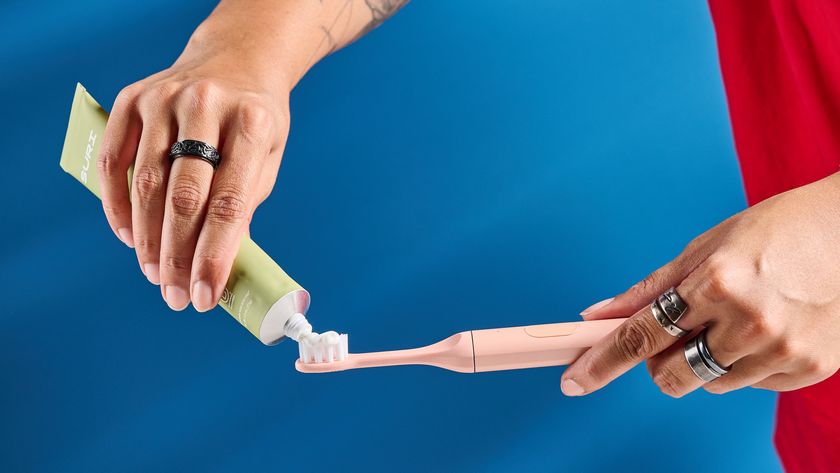 the Suri 2.0 toothbrush in sunset bloom pink colorway with a plant-based head and aluminum body, pictured with its uv cleaning travel case and the suri toothpaste