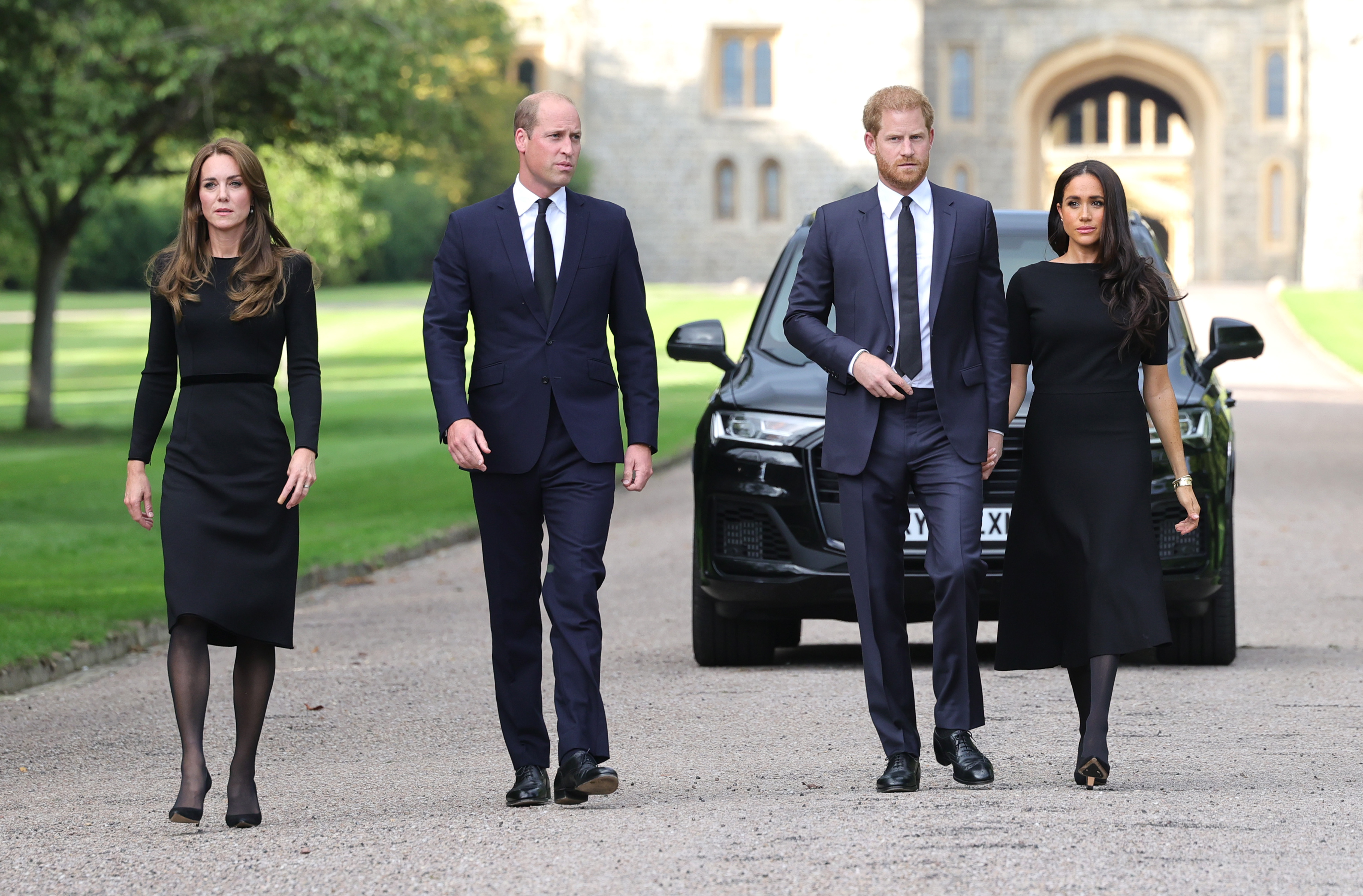 Princess Kate, Prince William, Meghan Markle and Prince Harry walking in front of a car at Windsor Castle
