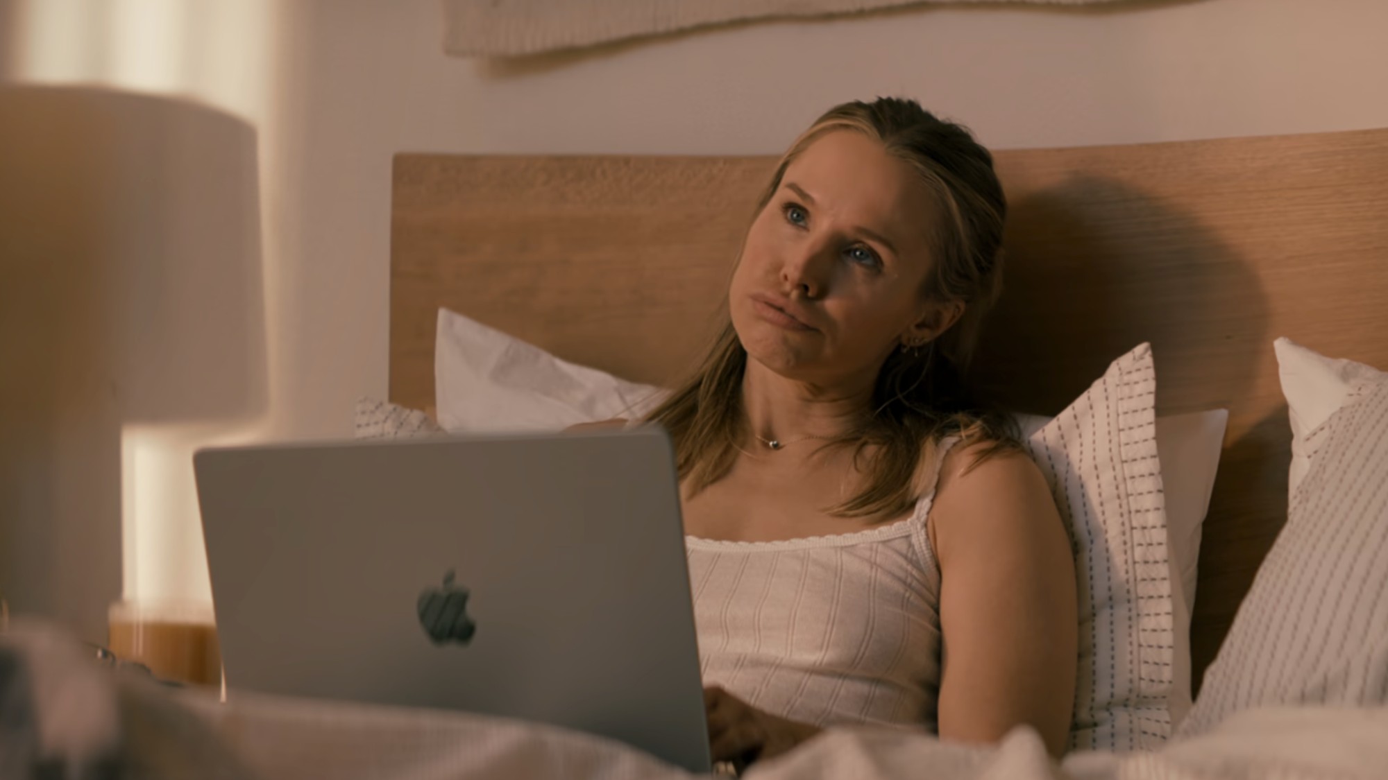 Kristen Bell in bed with her computer, looking annoyed in Nobody Wants This