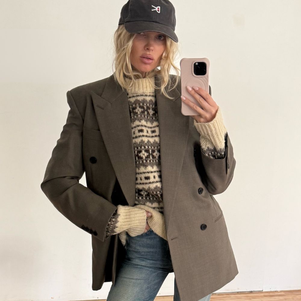 Elsa Hosk takes a mirror selfie wearing blue jeans with a mole-coloured blazer and matching heels.