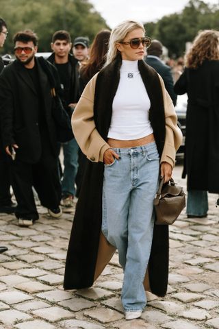 woman wearing white t shirt, coat, jeans, and mesh ballet flats